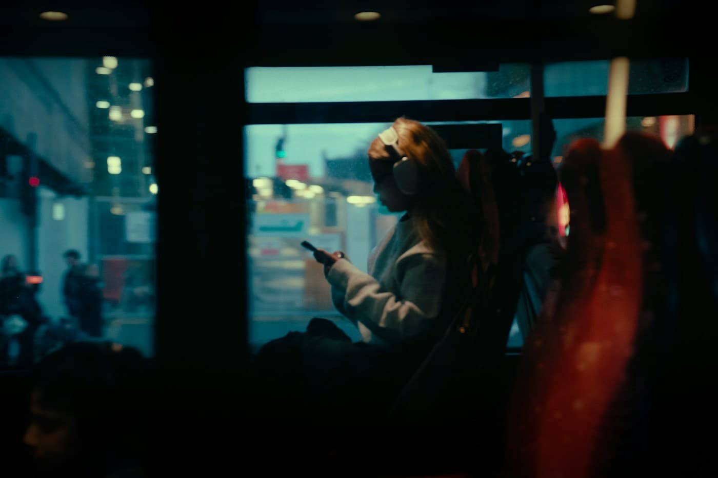 Pessoa usando o celular dentro do ônibus à noite