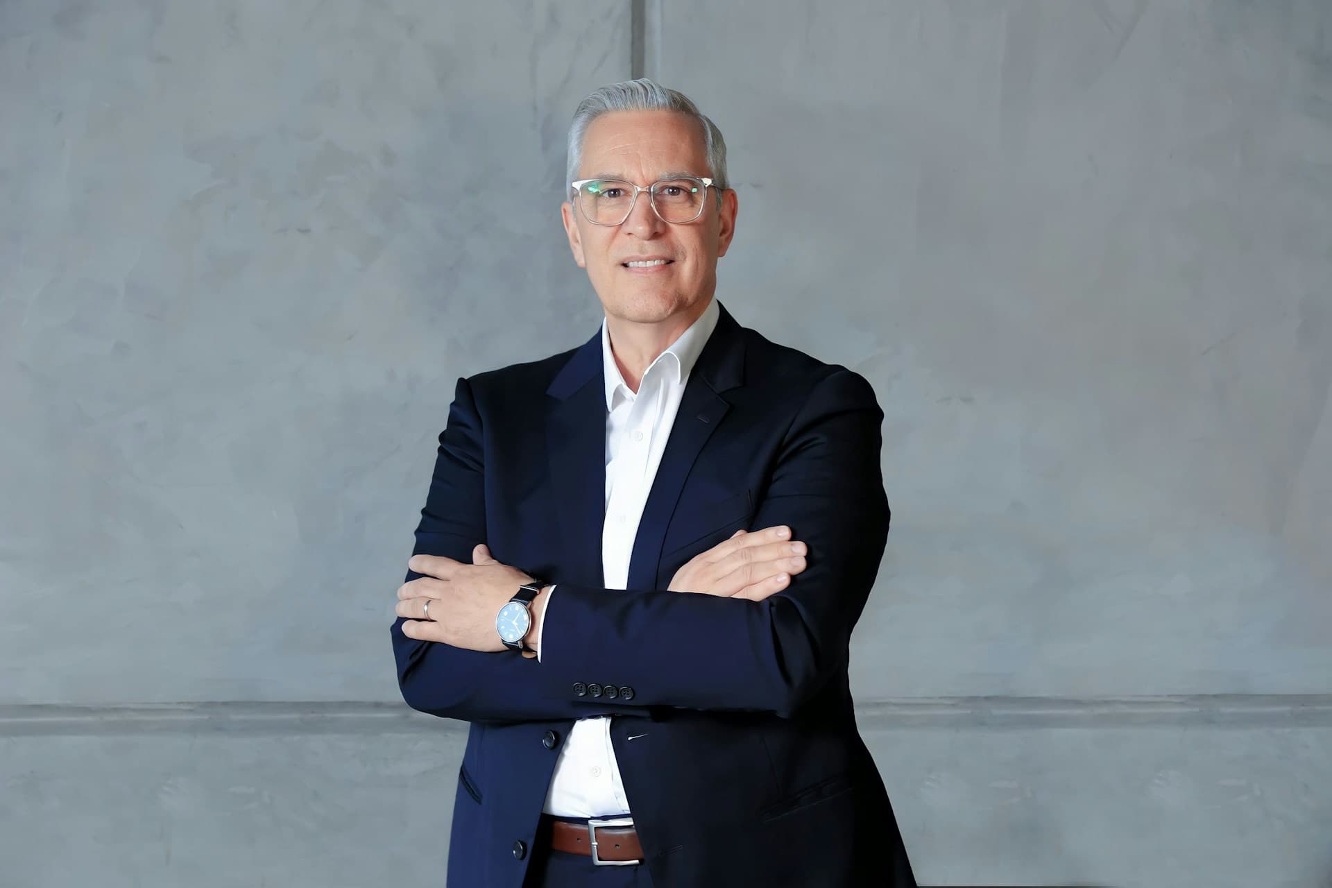 Executivo de terno com os braços cruzados, confiante