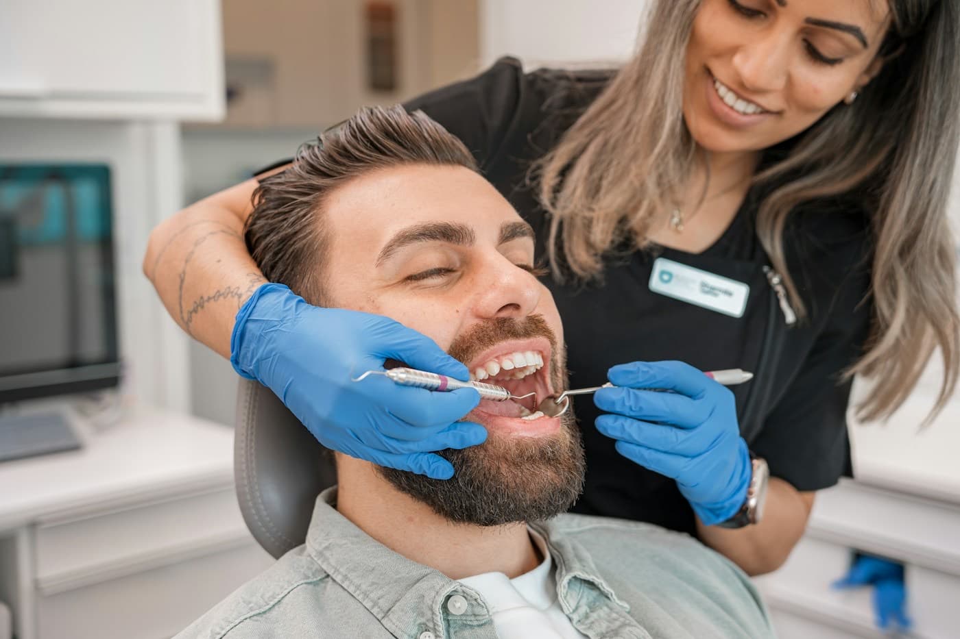 Paciente sorrindo na cadeira do dentista durante uma consulta