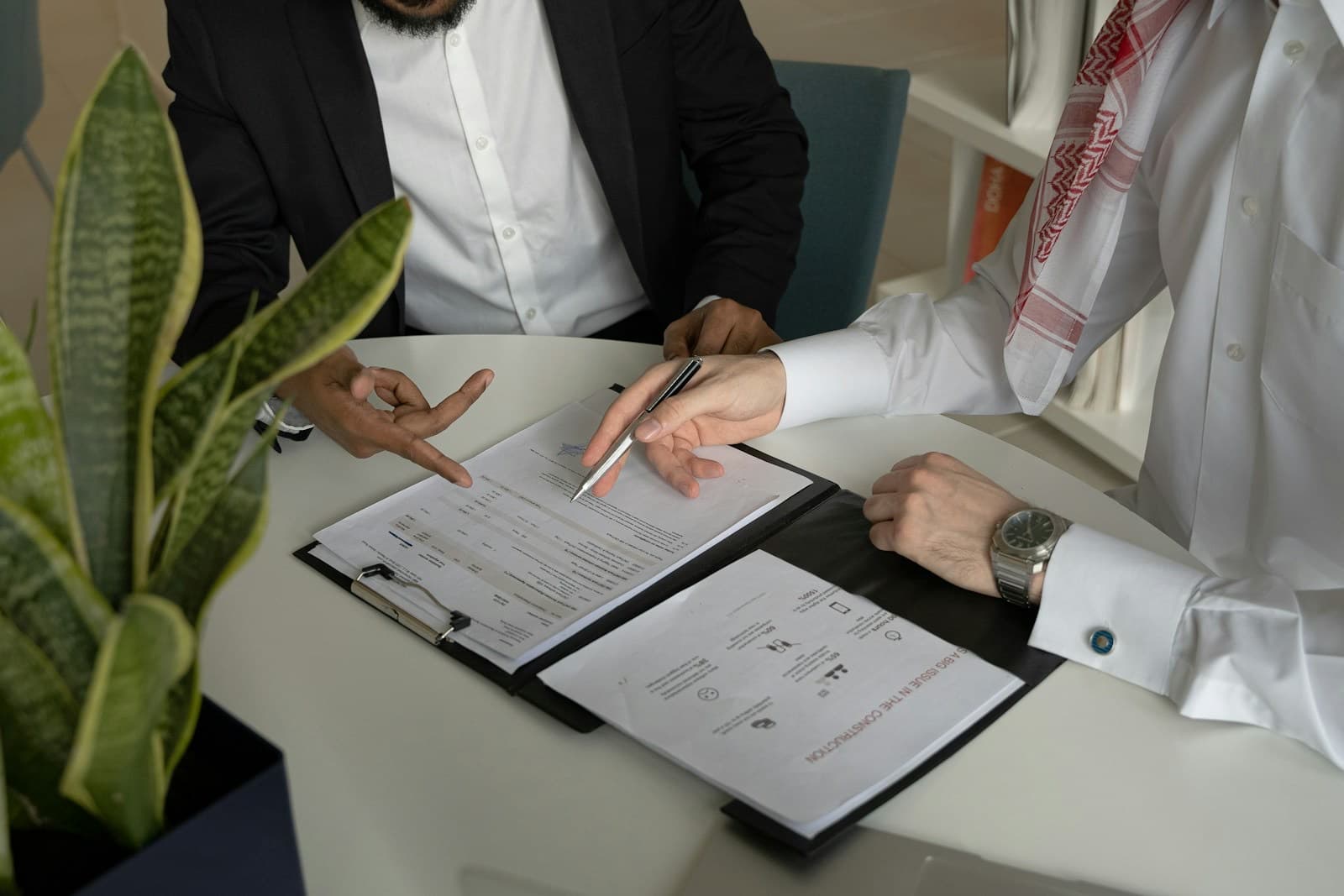 Duas pessoas revisando e assinando um contrato à mesa