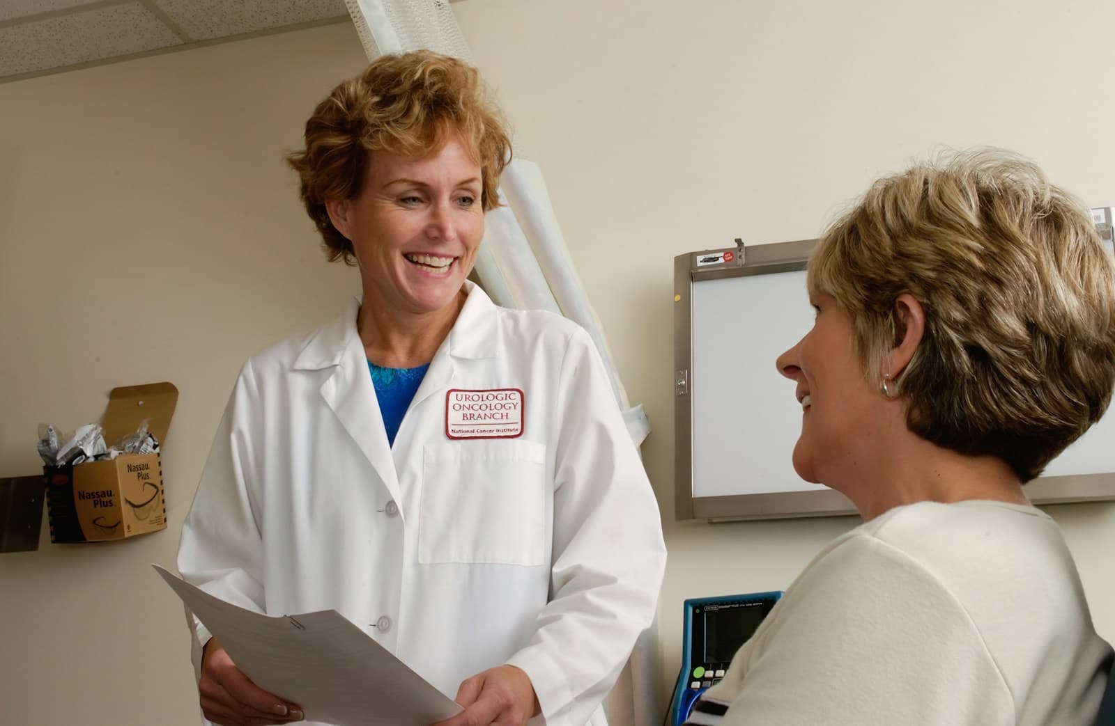 Médica sorridente conversando com uma paciente na clínica