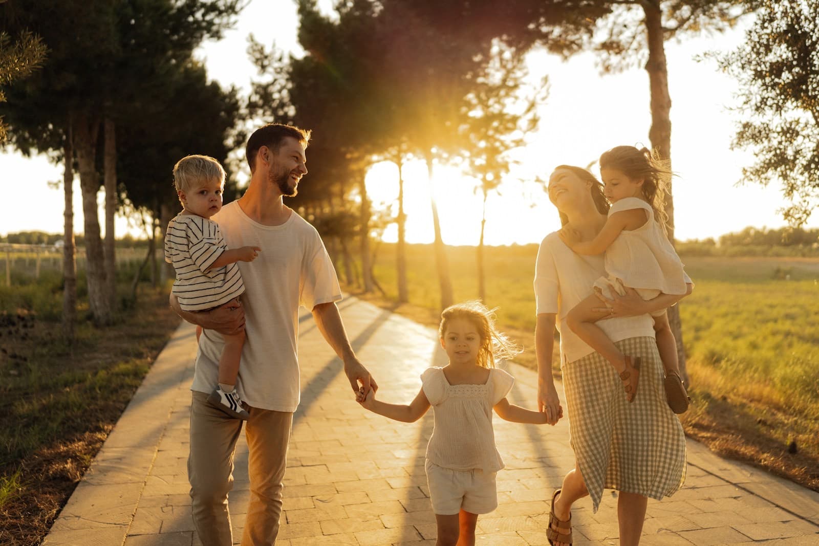 Família caminhando de mãos dadas em um parque ao pôr do sol